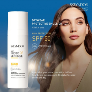 Skeyndor Age Photo Defense SPF 50 Daywear Protective Emulsion, botol produk dan model wanita dengan latar belakang langit biru.